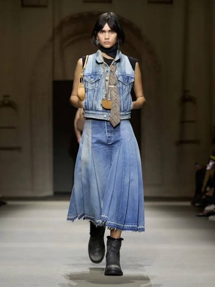 Foto de modelo usando conjunto jeans destroyed da Coach, uma das tendências da Semana de Moda de Nova York 2025