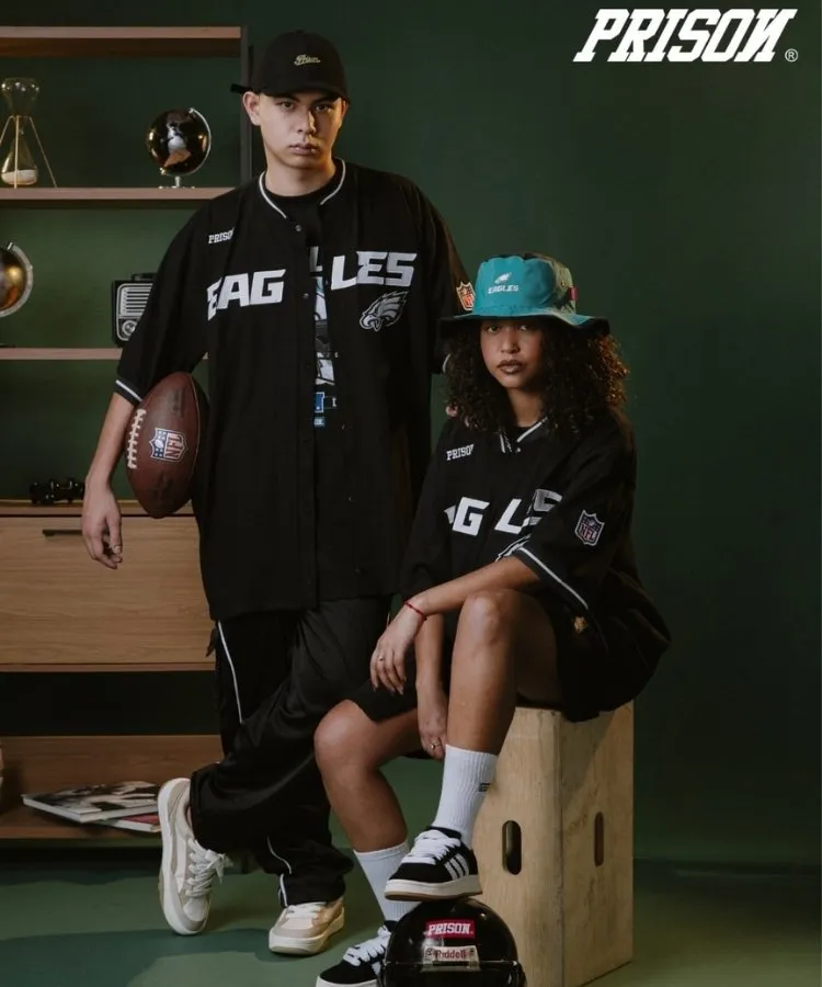 2 modelos, um homem e uma mulher, usando o mesmo look da marca Prison: camisa preta e shorts oversized
