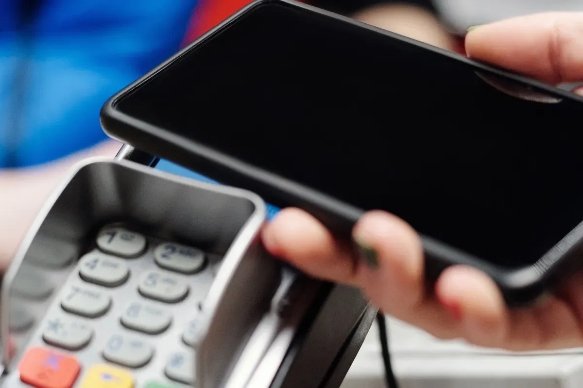 Pagamento com smartphone em terminal, representando cuidados com transações digitais e prevenção a fraudes no Pix
