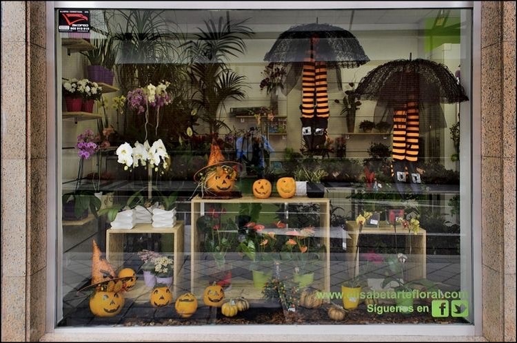 Floricultura com decoração de Dia das Bruxas, com guarda-chuvas pretos, meias pretas e laranjas, abóboras