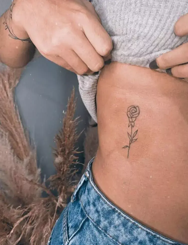 Tatuagem de flor na costela pequena em fineline