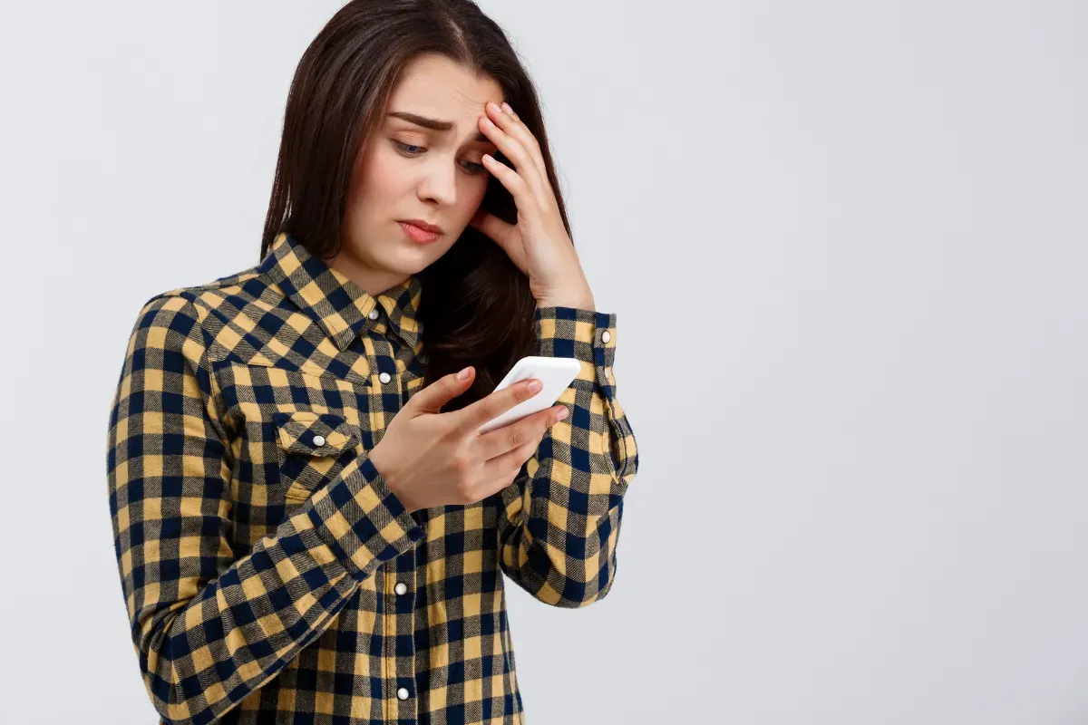 Mão segurando smartphone sobre terminal de pagamento durante uma transação digital