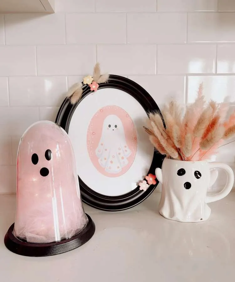 Porta-retrato com foto de fantasma foto, ao lado de caneca de fantasma e outro objeto