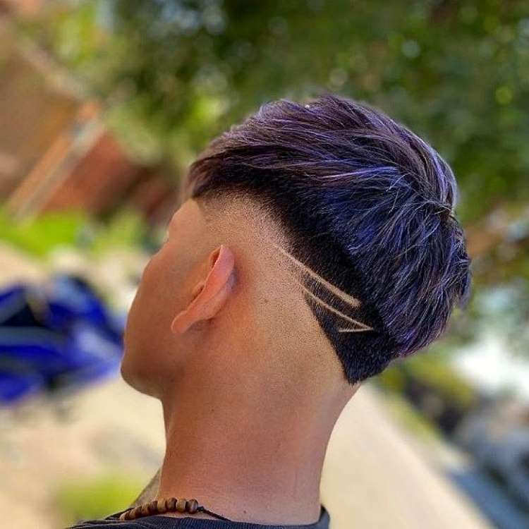 Homem com fios fade + riscos + luzes roxa