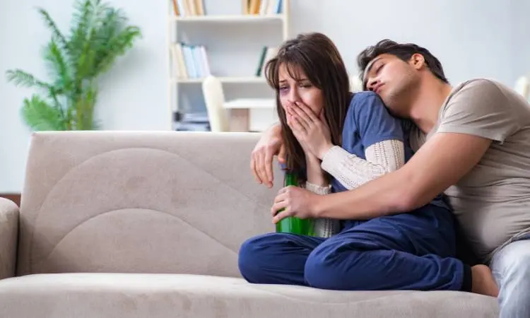 Casal em relacionamento abusivo e mulher chorando com olho roxo.