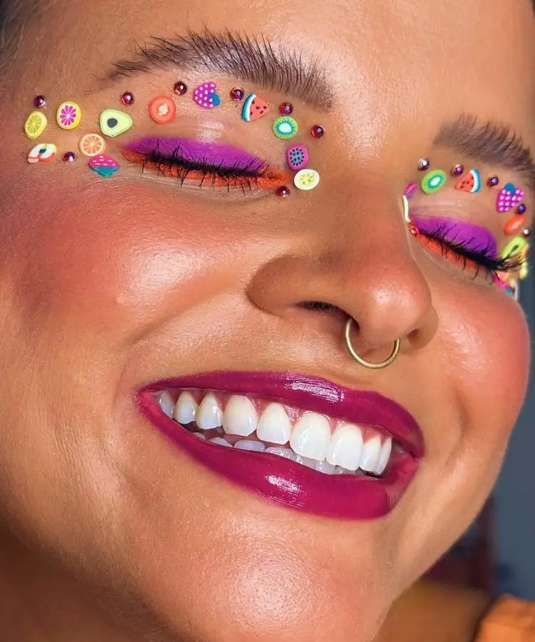 Foto de rosto de mulher com make de Carnaval com aplicação de frutinhas coloridas