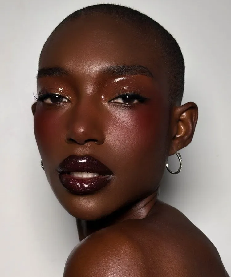 Foto de mulher de pele negra usando batom ameixa