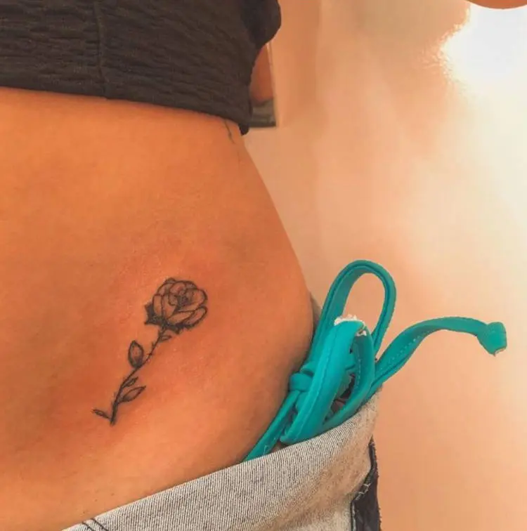 Tatuagem de rosa na cintura