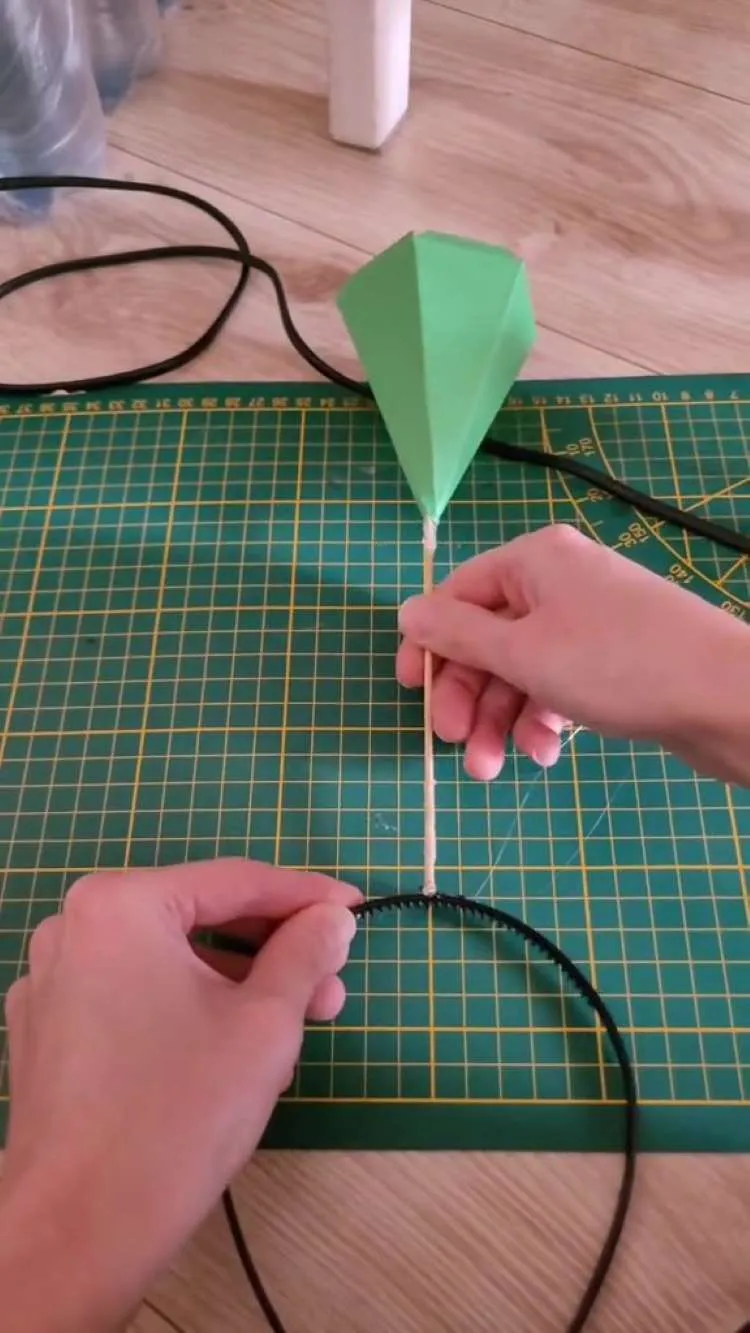 Fixando palito de madeira no arquinho do passo a passo de prisma para tiara de Halloween