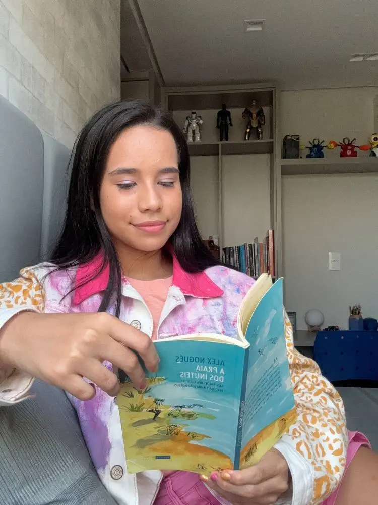 Malu Lira sentada lendo livro 
