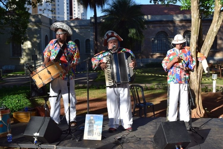 Três cantores com instrumentos como sanfona, além de usando chapéu nordestino