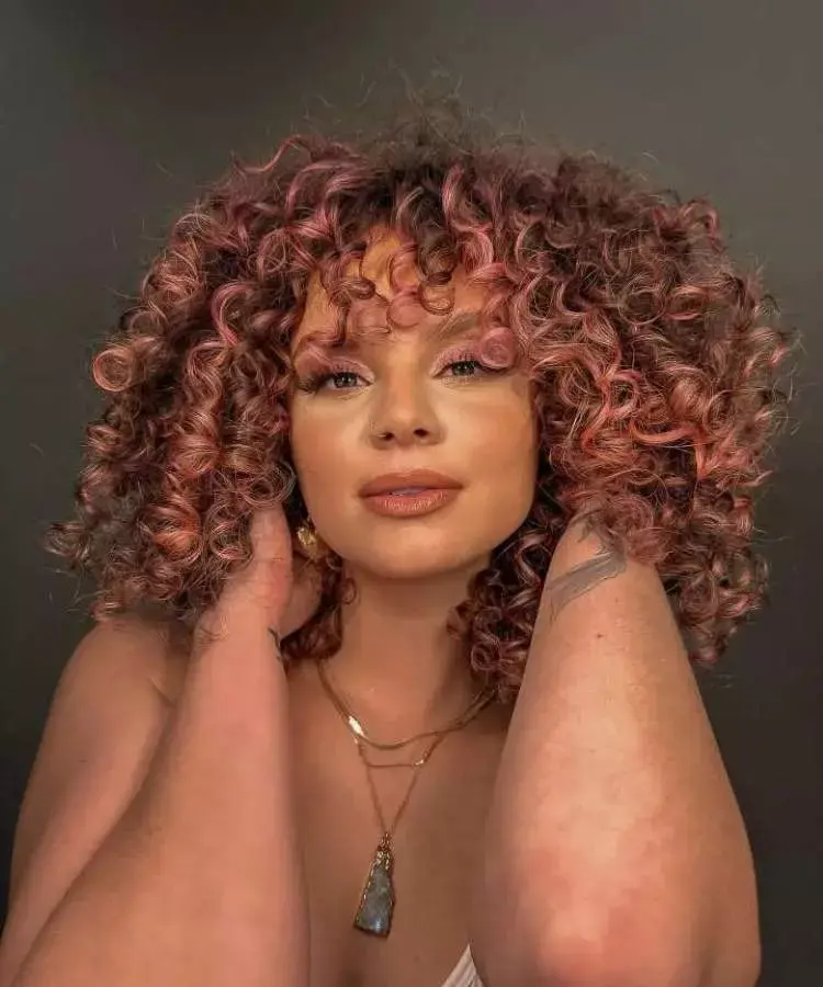 Mulher com corte de cabelo médio cacheado franja assimétrica