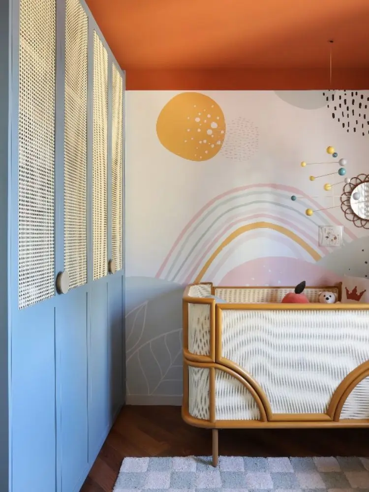 Quarto de bebê com armário azul claro e pintura em tons pastéis 