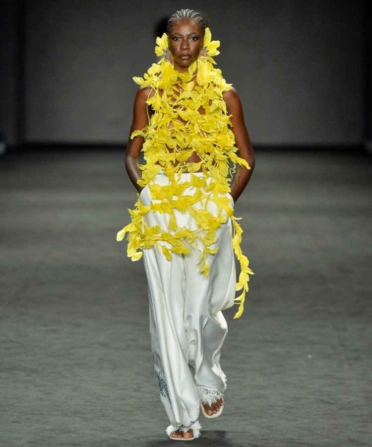 Modelo na passarela usando blusa de plumas, uma das tendências do Rio Fashion Week 2026