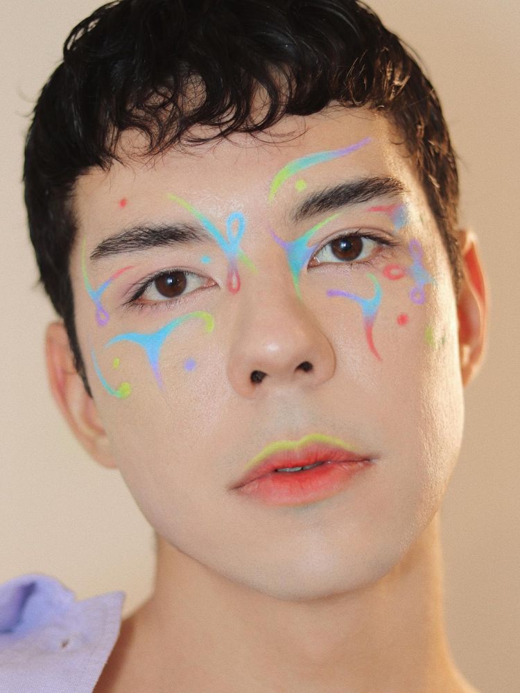 Homem de pele clara com desenhos neon pelo rosto