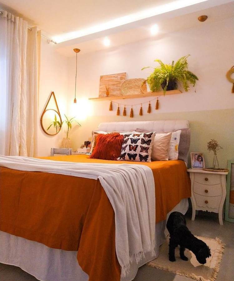 Quarto com planta samambaia pendurada em um prateleira sob a cabeceira da cama