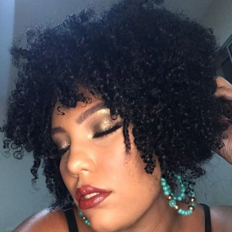 Mulher de pele morena, maquiada, com cabelo chanel curto crespo