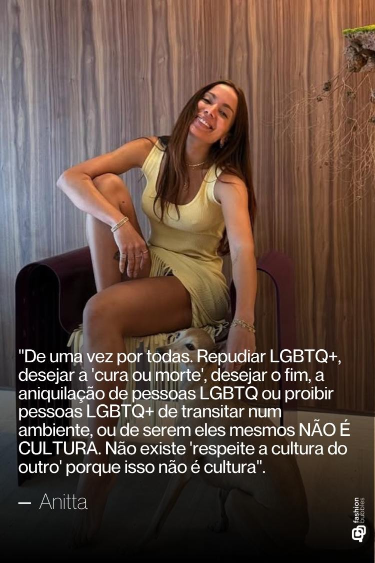 Uma mulher sorridente com cabelos longos e castanhos, vestindo um vestido claro, está sentada em uma poltrona escura. A imagem apresenta uma citação atribuída a Anitta, que condena a discriminação contra pessoas LGBTQIA+. Imagem ilustra matéria sobre LGBT frases dos famosos.