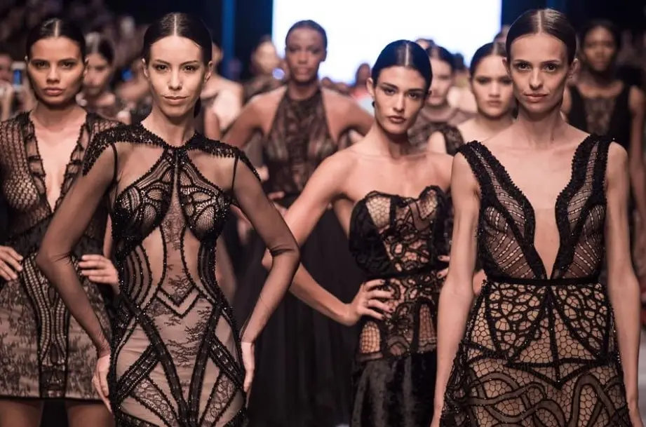 Várias modelos posando em um desfile com vestidos pretos da coleção Oscar Niemeyer de Ivanildo Nunes