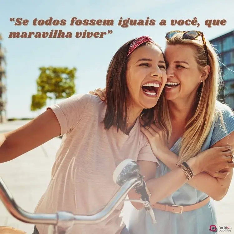 Imagem de duas amigas de pele clara, uma de cabelo escuro e outra loira. Ambas sorriem, a de cabelo escuro usa uma blusa rosa clara e a outra usa uma blusa azul clara. Elas estão atrás de um guidão de bicicleta. Acima, há a frase "Se todos fossem iguais a você, que maravilha viver". 