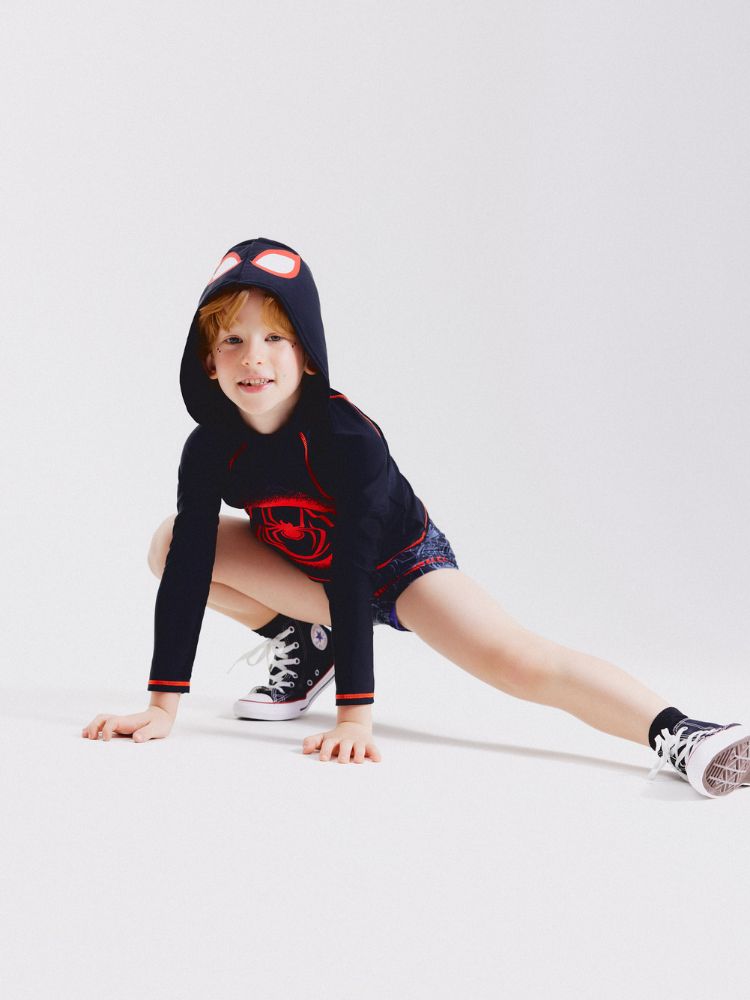 Menino de pele clara usando moletom do homem aranha e shorts