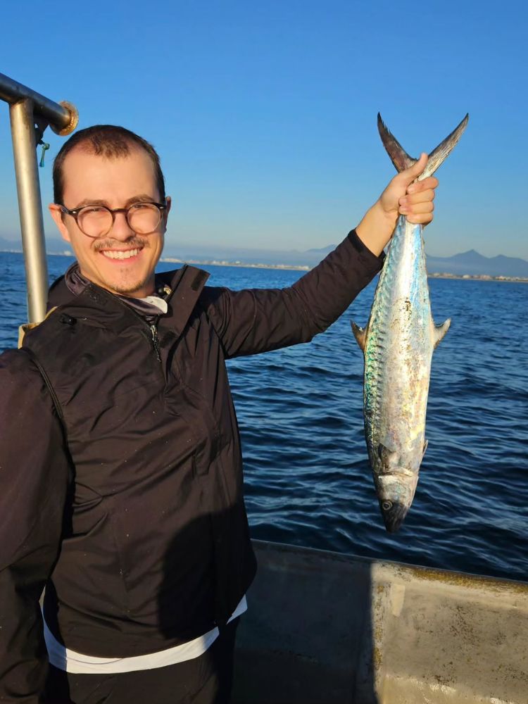Rui Morschel de roupa preta em barco segurando um peixe