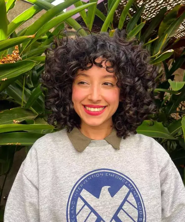 Mulher com corte de cabelo médio ondulado franja assimétrica