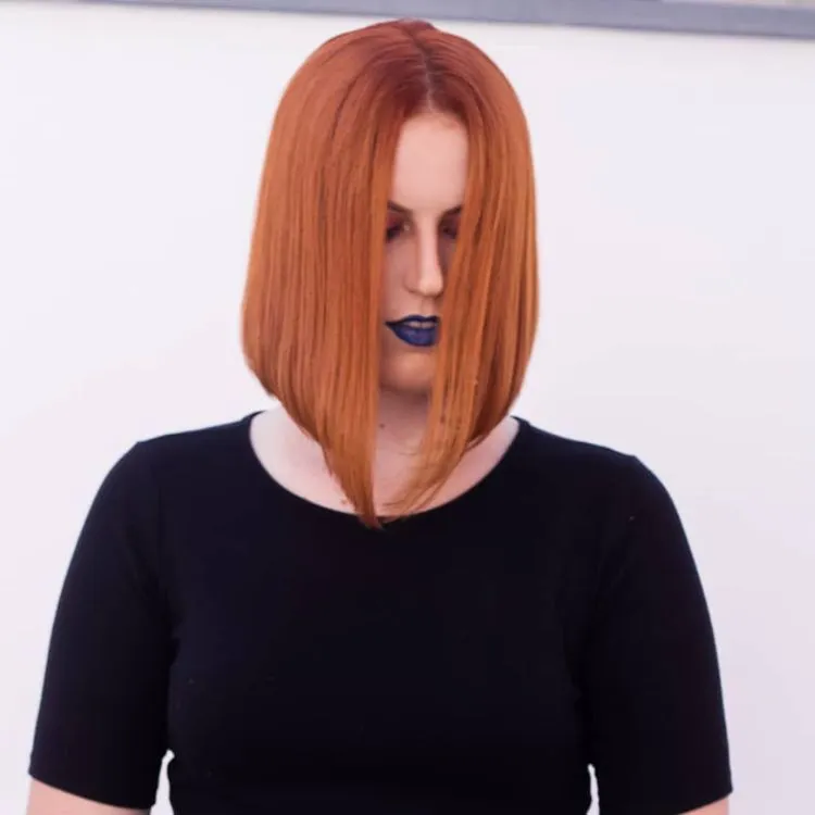 Mulher de pele clara de cabelo chanel ruivo bico e batom auzl