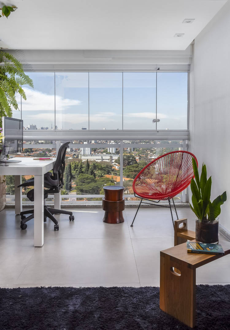 Home office com parede de vidro.
