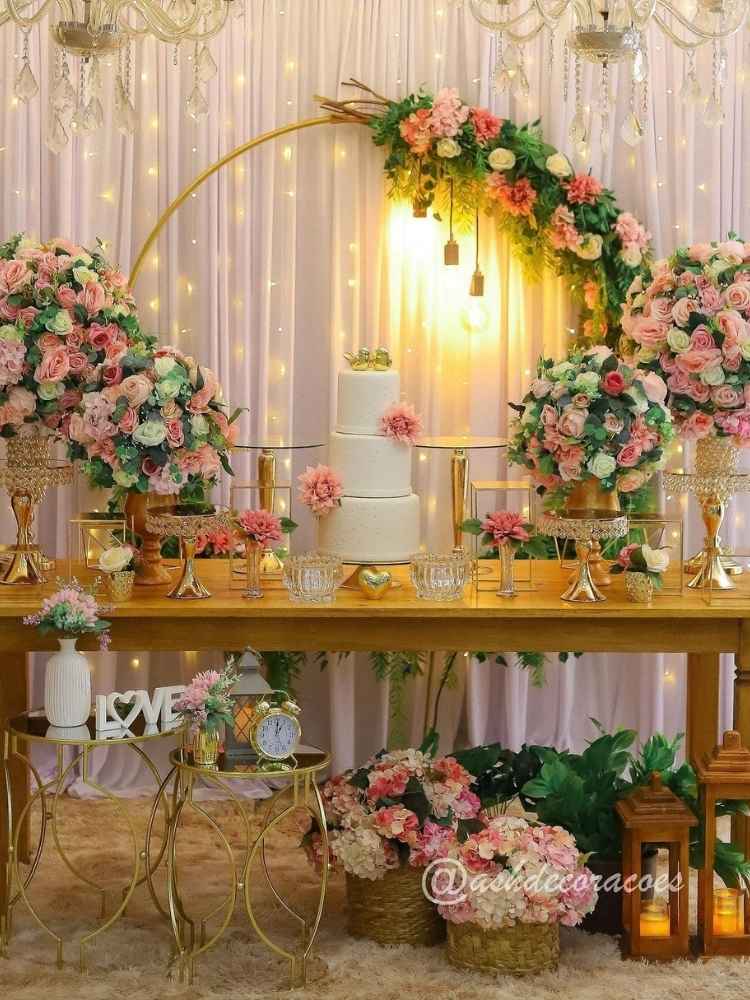Decoração de mesa de bolo de casamento civil com flores cor de rosa e branca.