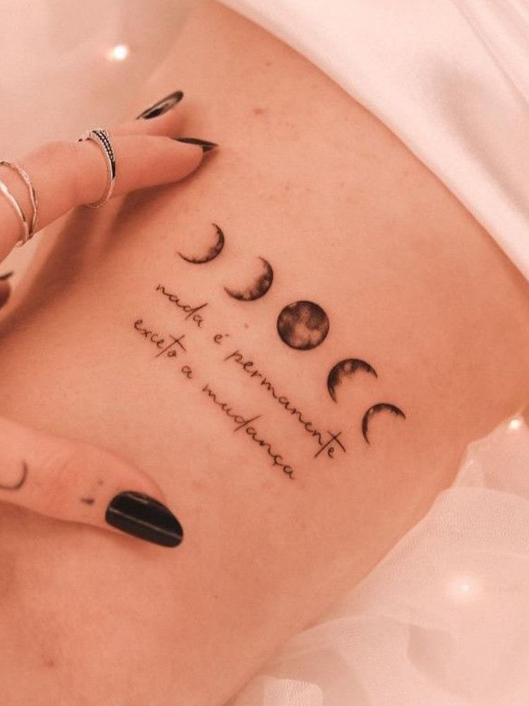 tatuagem com a frase "nada é permanente exceto a mudança" e as fases da lua. 