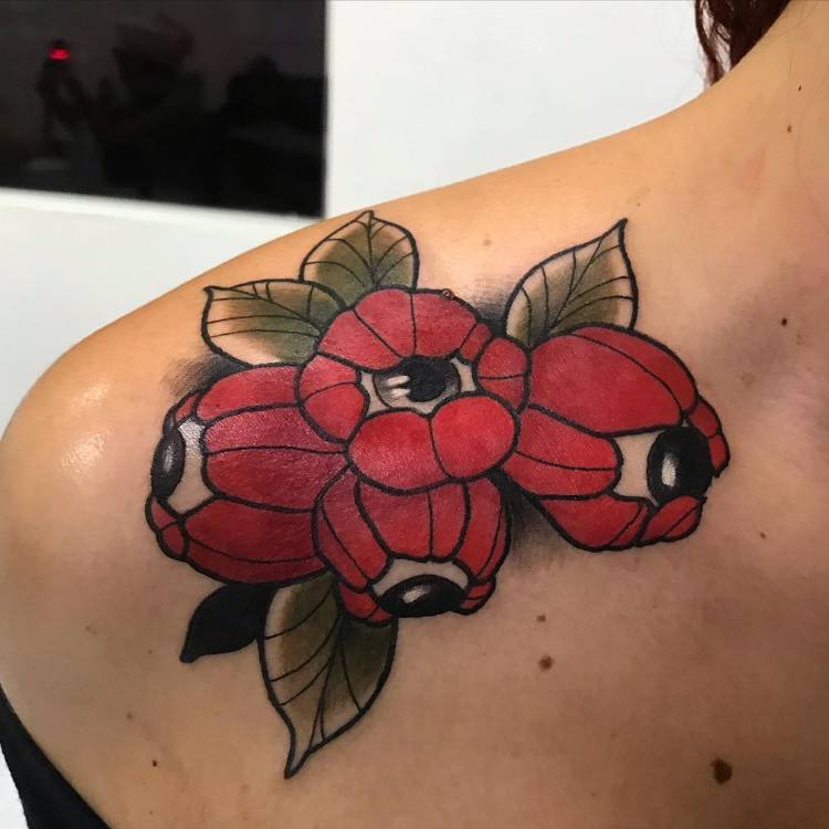 Mulher de pele clara com tatuagem old school de guaraná no ombro