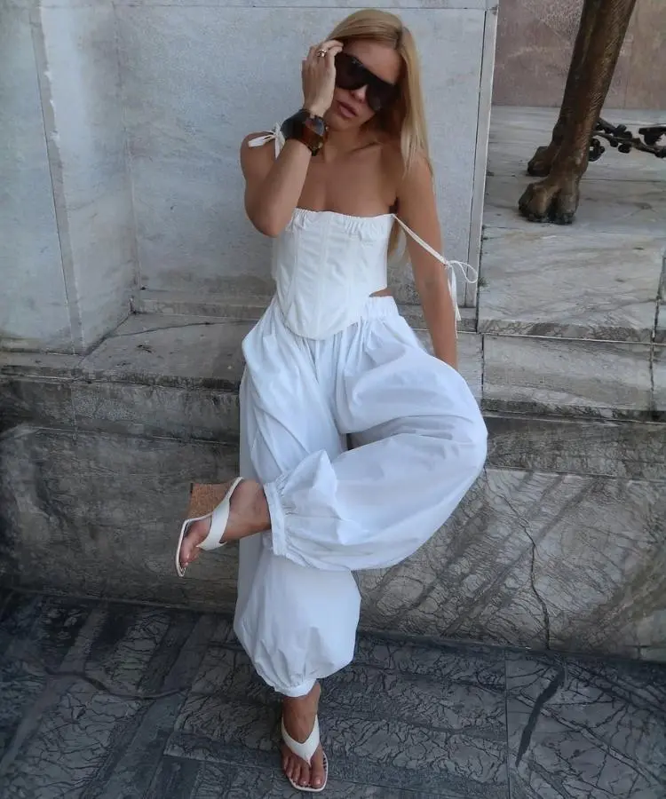 Foto de influencer usando corset, calça aladim e anabela de cortiça, uma das tendências de sandálias para o verão 2026