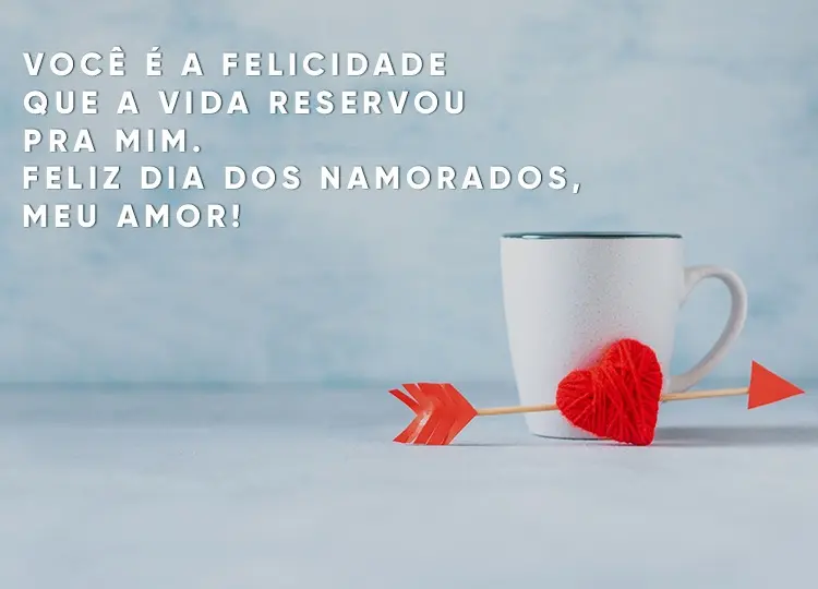 Foto de fundo azul com caneca branca, coração flechado e frase "Você é a felicidade que a vida reservou pra mim. Feliz Dia dos Namorados, meu amor!"