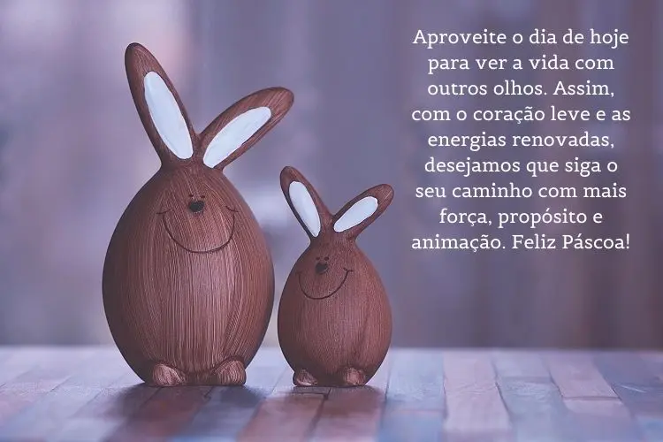 Foto de dois enfeites marrons de coelho e frase: Aproveite o dia de hoje para ver a vida com outros olhos. Assim, com o coração leve e as energias renovadas, desejamos que siga o seu caminho com mais força, propósito e animação. Feliz Páscoa!