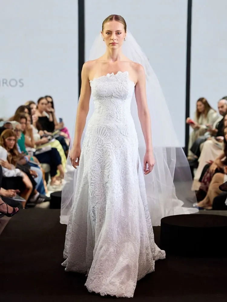 Mulher de pele clara com vestido de noiva corseletado, bordado e com véu