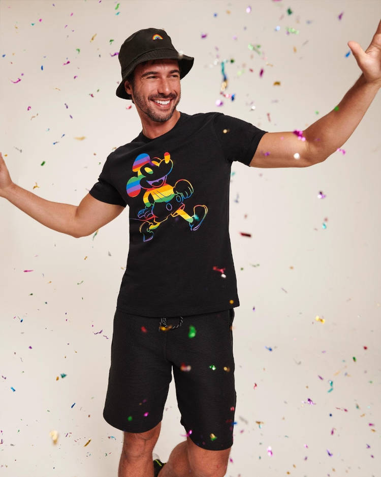 Homem com camiseta do Mickey e chapéu preto.
