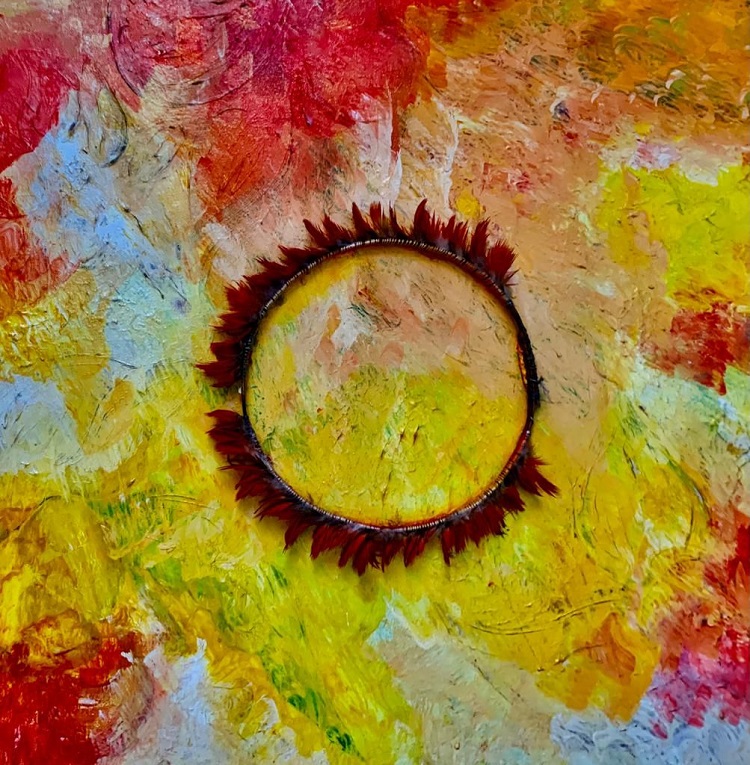 Obra de arte abstrata em tons de vermelho, amarelo e branco, com cocar de penas no centro