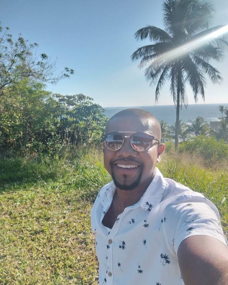 Davi Brito, campeão do BBB 24, usando óculos de sol e camisa branca em área externa