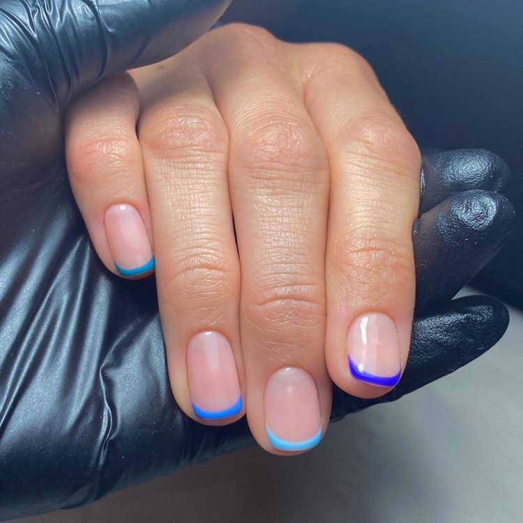 Unhas decoradas em tons de azul com francesinha
