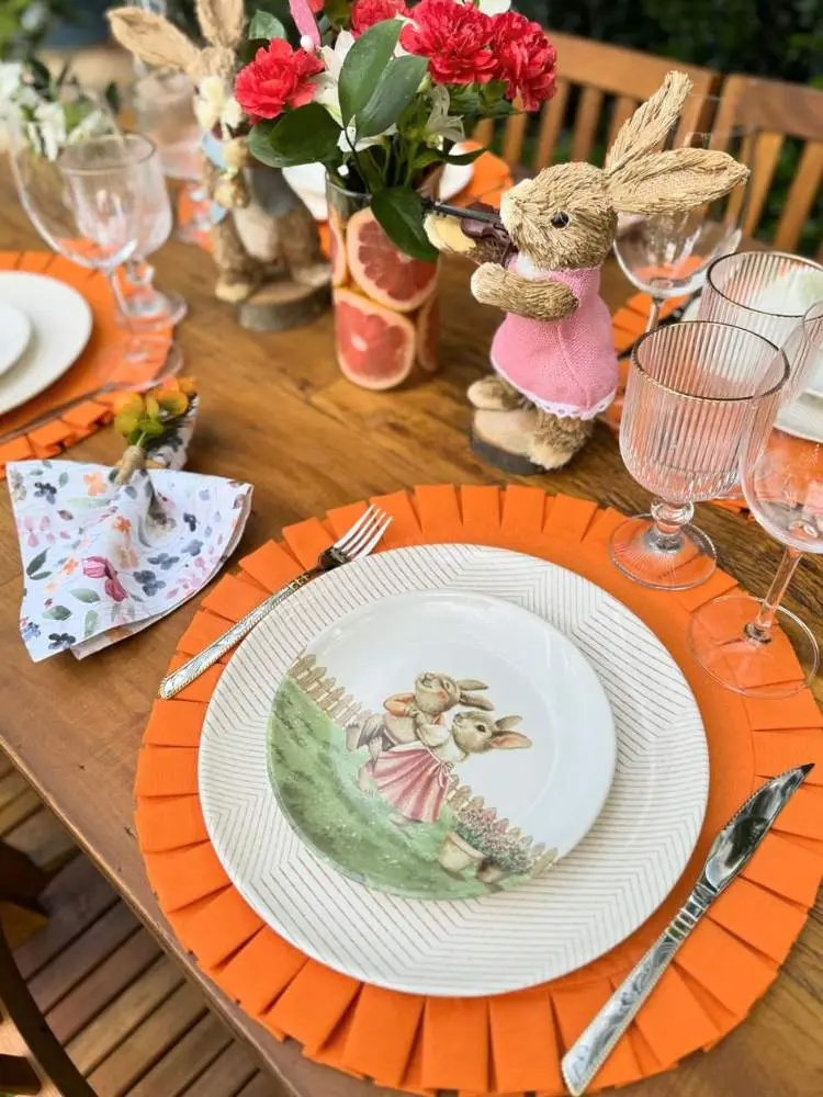 Mesa posta em laranja com pratos de coelho 