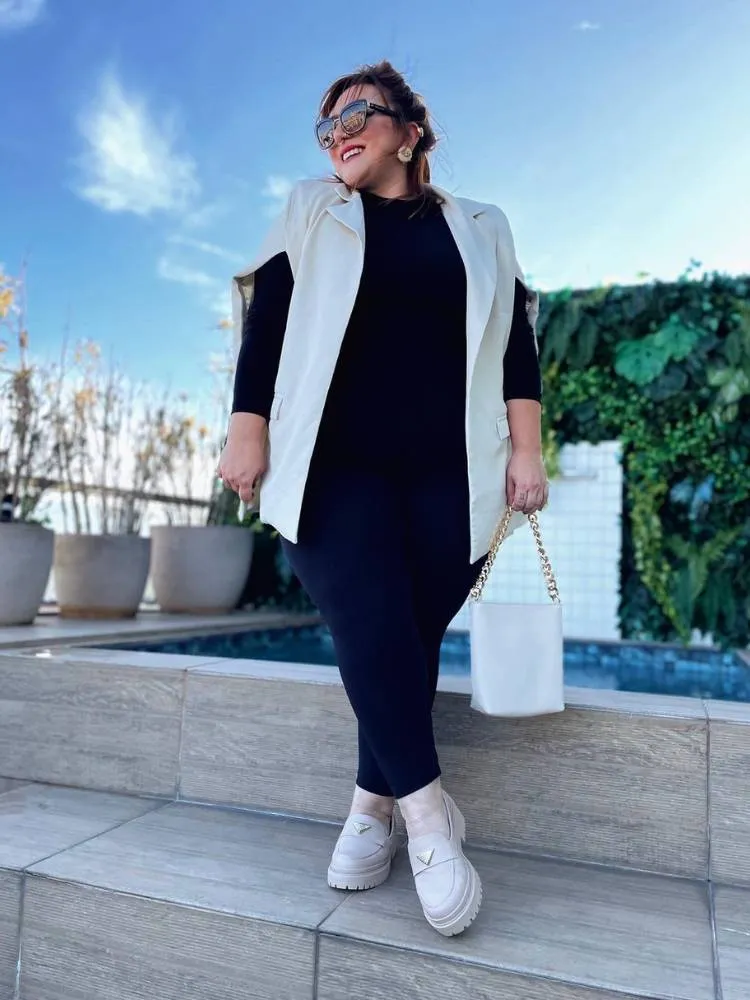 mulher usando look preto com blazer, bolsa e mocassim em off white