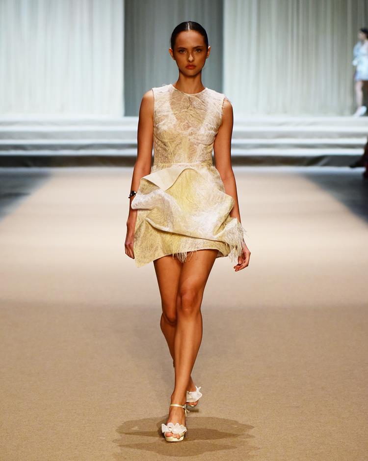 modelo no desfile Melk Z-Da com vestido curto branco e amarelo