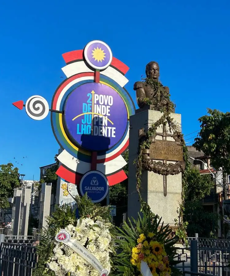 Obra escrito 2 de julho Povo Independente  ao lado de estátura em Salvador