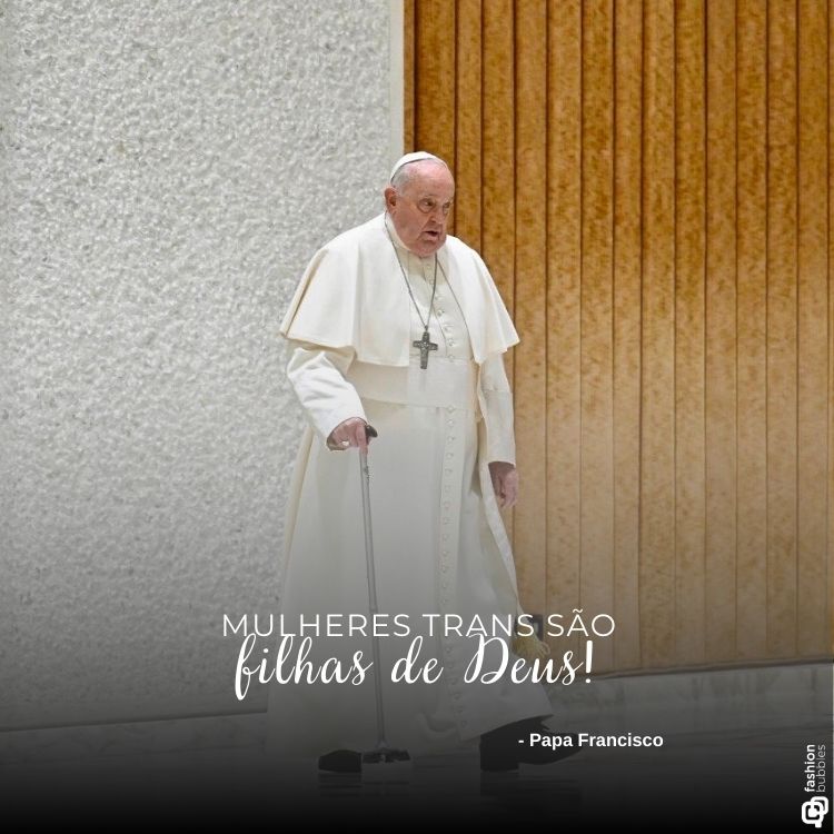 O Papa Francisco aparece caminhando com o auxílio de uma bengala, vestindo suas tradicionais roupas brancas. Ao fundo, uma parede texturizada e madeira clara. Em destaque, a frase: "Mulheres trans são filhas de Deus!" seguida de sua assinatura.