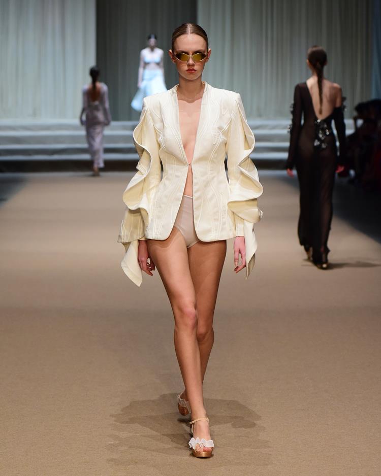 modelo no desfile Melk Z-Da com blazer branco e amarelo e óculos escuros