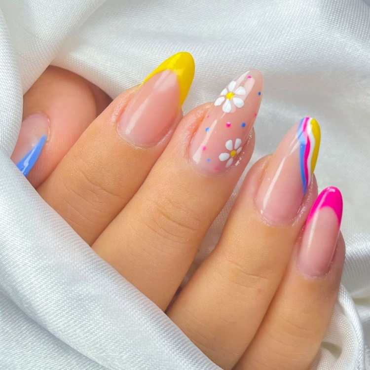 Unhas decoradas com flores e coloridas.