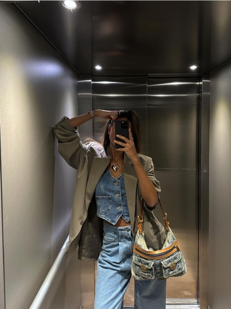 mulher usando corset jeans com calça jeans e blazer bege como sobreposição