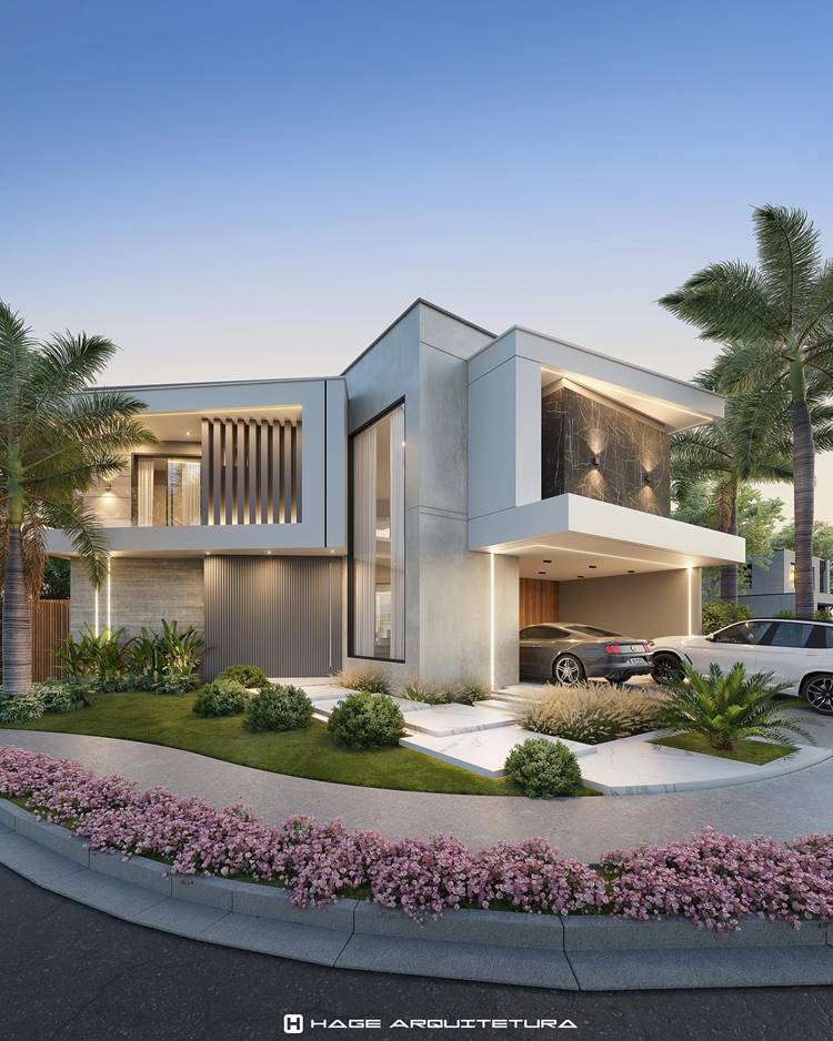Fachada de casa moderna com um carro na garagem, cercada de verde e flores. A casa tem um design arquitetônico elegante, com janelas grandes e uma combinação de texturas brancas e de madeira. Há iluminação externa que cria um ambiente acolhedor. O céu está passando do crepúsculo para a noite, lançando uma luz suave sobre a cena. A imagem tem o texto “HAGE ARQUITETURA” no canto inferior direito, que pode ser o nome do estúdio responsável pelo projeto