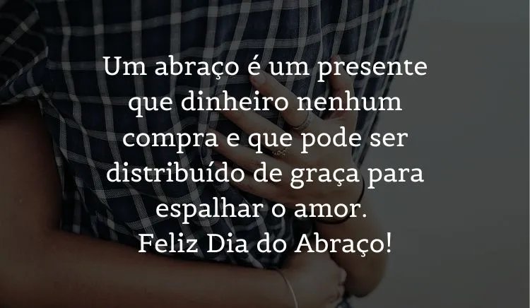 Zoom em abraço em pessoa usando camisa xadrez e frase: Um abraço é um presente que dinheiro nenhum compra e que pode ser distribuído de graça para espalhar o amor. Feliz Dia do Abraço!